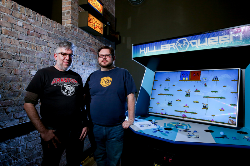 Nikita Mikros (left) and Josh DeBonis (right) with Logan Arcade’s Killer Queen machine